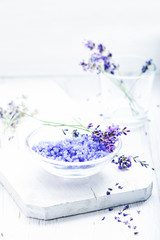 ingredients for lavender spa, flower and salt on white wooden background.