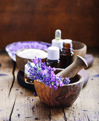 Lavender spa , bunch of lavender flowers , essential oil and salt on a rustic wooden background.