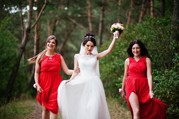 Fototapeta na wymiar Fantastic bride with awesome bridesmaids having fun in the forest on a wedding day.