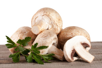 Champignon mushrooms on wooden table with white background