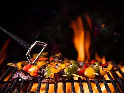 Tasty skewers on the grill with flames
