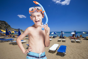 Happy little boy with snorkeling mask enjoying his summer vacations