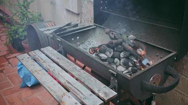 Backyard barbeque grill with smoking charcoal and fire, ready to receive portion of meat and vegetables, for party or event