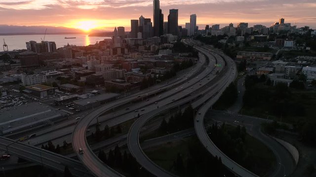 Amazing Sunset Aerial of Seattle, Washington with Vibrant Orange Glow on Skyscraper Buildings in City Skyline