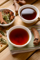 relaxing herbal tea in the bowl with ingredients around