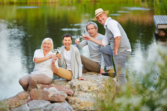 Senioren sitzen am See im Sommer
