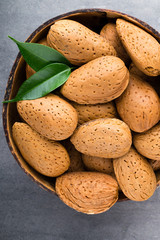 Group of almond nuts with leaves.Wooden background.