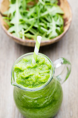 Rucola smoothie, on the grey  background.