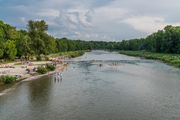 Erholungssuchende am Isarstrand in München Thalkirchen am Feierabend beim Erfrischen