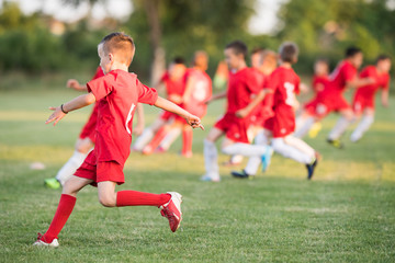 Obraz premium Kids soccer football - children players exercising before match on soccer field