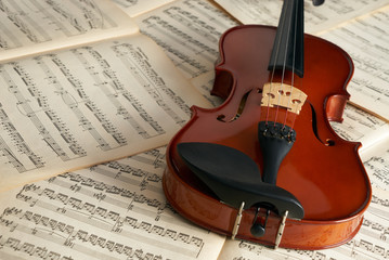 Close-up photo of vintage violin with bow and musical notes. Cello or fiddle and fiddlestick on...