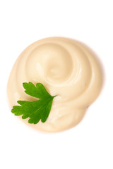 Mayonnaise swirl with a parsley leaf isolated on a white background close-up. Top view