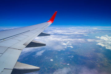 Obraz premium Aerial view from airplane window. Airplane flying above land with beautiful clouds in the sky