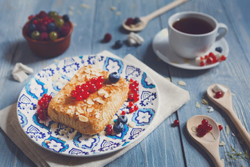 Pastry pie, tea and berries at blue rustic wood