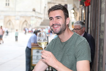 Happy man holding white wine