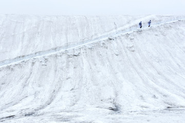 Hiker walking uphill on path in the snow