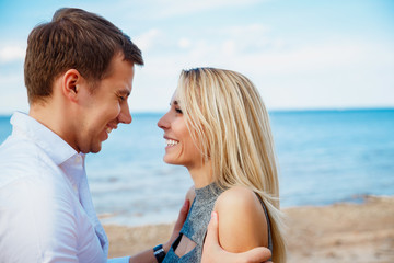 Romantic young couple standing head to head at beach
