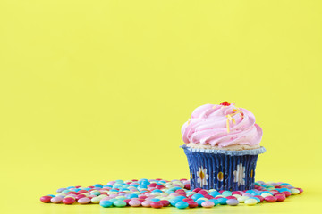 Tasty cupcakes with candles on colorful background