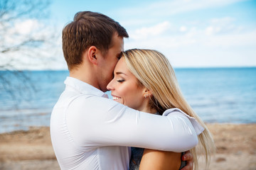 Romantic young couple standing head to head at beach