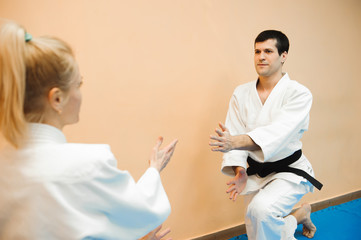 Man and woman fighting at Aikido training in martial arts school