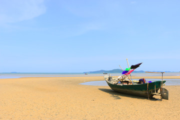 Beautiful blue sky on the wooden fishing boat on a sand beach
