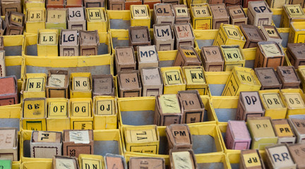 Stack of cardboard boxes with alphabet letters  and syllables. Vintage game at flea market in Paris (France).