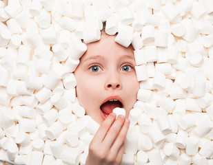 Girl putting marshmallow to mouth