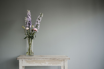 summer flowers in a glass vase on old kitchen table 