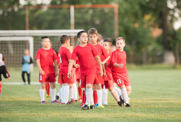 Obraz premium Kids soccer football - children players exercising before match on soccer field
