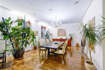 Large dining table in the interior of the apartment in a stylish modern design.
