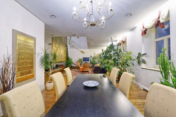 Large dining table in the interior of the apartment in a stylish modern design.
