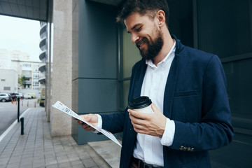 Business man smiling, business man looking at documents, business man with coffee mug