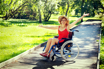 Fototapeta na wymiar woman on wheelchair rising hands up