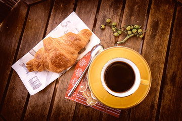 café et croissant sur une table en bois
