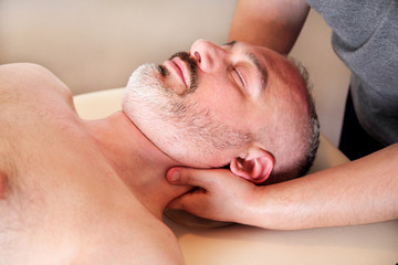 Obraz na płótnie Canvas Massage relax professional wellness center. Masseuse human hands massaging for neck. Man taking a massage neck muscles at massage table. Body care. Male body massage treatment in spa studio.