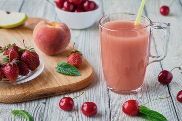 Fresh fruit smoothies in a glass. Apple, cherry, peach, strawberry wooden table.