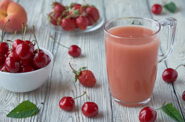 Fresh fruit smoothies in a glass. Apple, cherry, peach, strawberry wooden table.