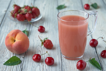Fresh fruit smoothies in a glass. Apple, cherry, peach, strawberry wooden table.
