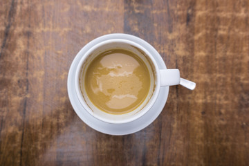 Cremiger Kaffee in weißer Tasse auf Tisch