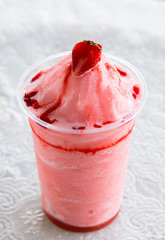 Strawberry in a clear plastic glass.