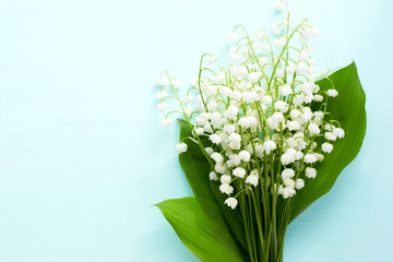 Bouquet of fresh white lilies of the valley in a wooden window still. Top view