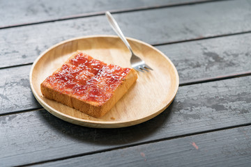 yam roselle spread on homemade bread whole wheat - top view food on wooden table.
white bread with strawberry jam on a plate.