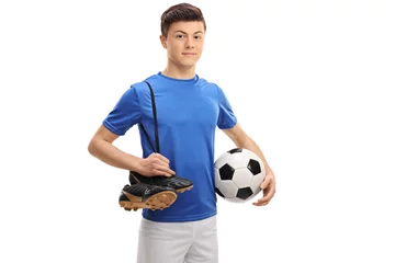 Fotobehang Teenage soccer player with football and pair of soccer shoes © Ljupco Smokovski