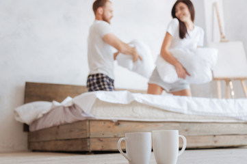 Happy couple having pillow fight in bed