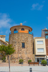Old tower in the Spanish town on the waterfront street of Cambri