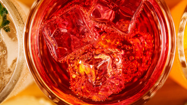 Bubbles On Ice Cubes In A Glass With A Red Cocktail Top View