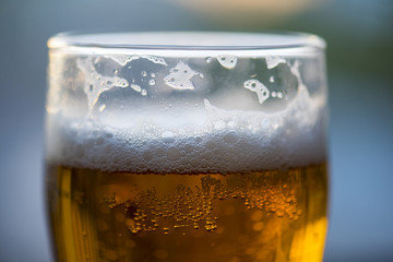 White foam in glass, close-up picture of beer
