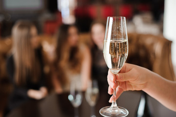 glass of champagne on the background of friends at a party