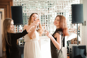 Portrait of smiling friends holding glass of champagne while dancing at bar