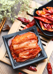Korean kimchi in black plate on bamboo